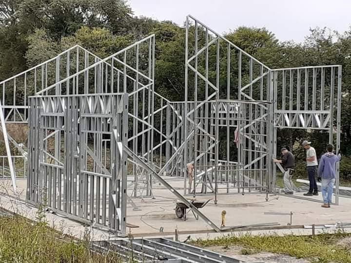 Equipe montando a estrutura metálica no terreno